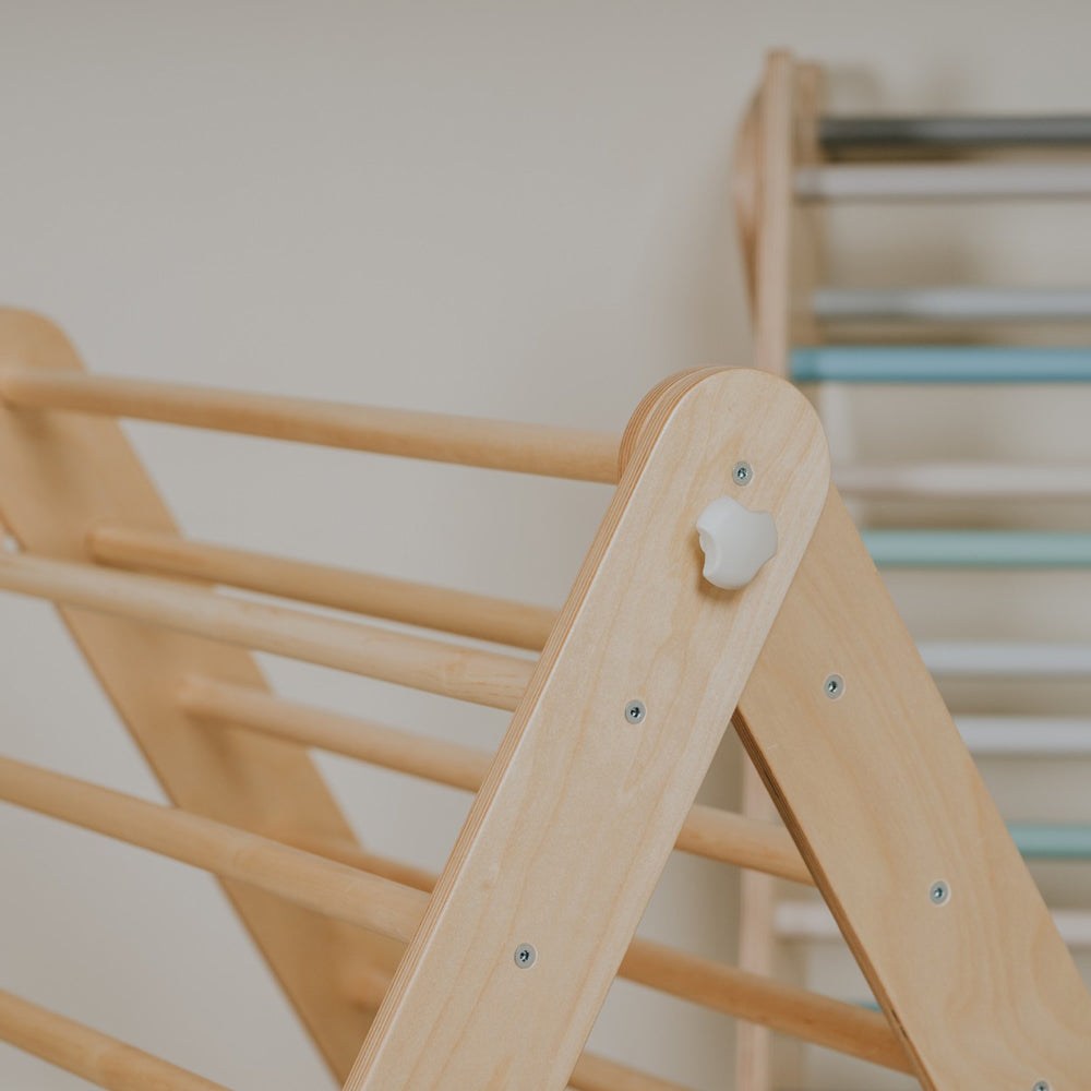 Nahaufnahme eines naturfarbenen Kletterdreiecks aus Birkensperrholz als vielseitiges Kinderspielgerät für Bewegung und Kreativität.