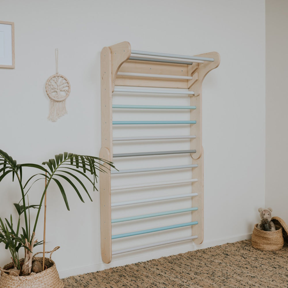 Pastellfarbene Sprossenwand aus Birkensperrholz für Kinder, fördert Motorik und Gleichgewicht in stilvollem, skandinavischem Design.