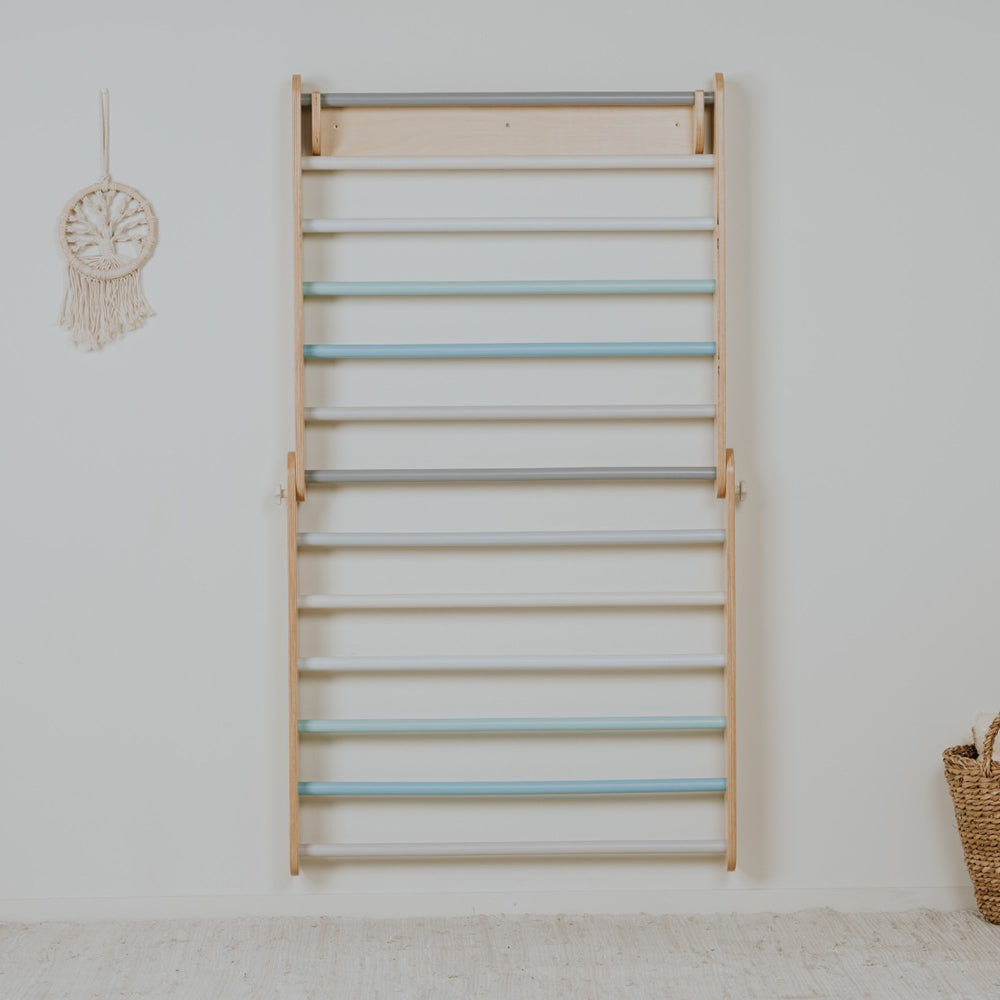 Kinderfreundliche Sprossenwand aus Birkensperrholz in Pastellfarben, fördert Bewegung und Motorik im Kinderzimmer spielerisch.