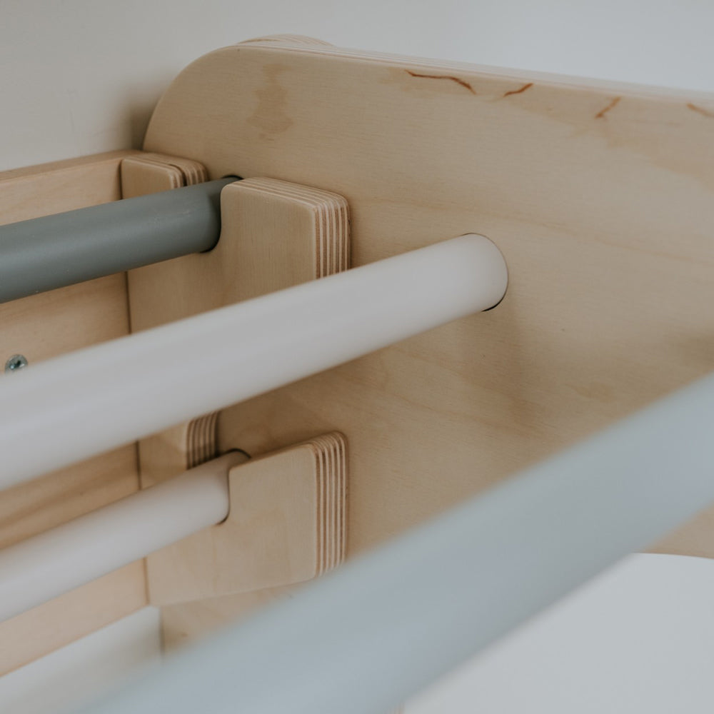 Nahaufnahme des 2in1 Kletterdreiecks aus Birkensperrholz mit pastellfarbenen Sprossen zur motorischen Förderung von Kleinkindern.