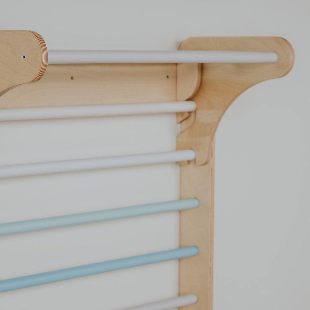Detailaufnahme der Pastellfarben Sprossenwand aus Birkensperrholz, ideal für motorische Förderung und spielerische Bewegung im Kinderzimmer.
