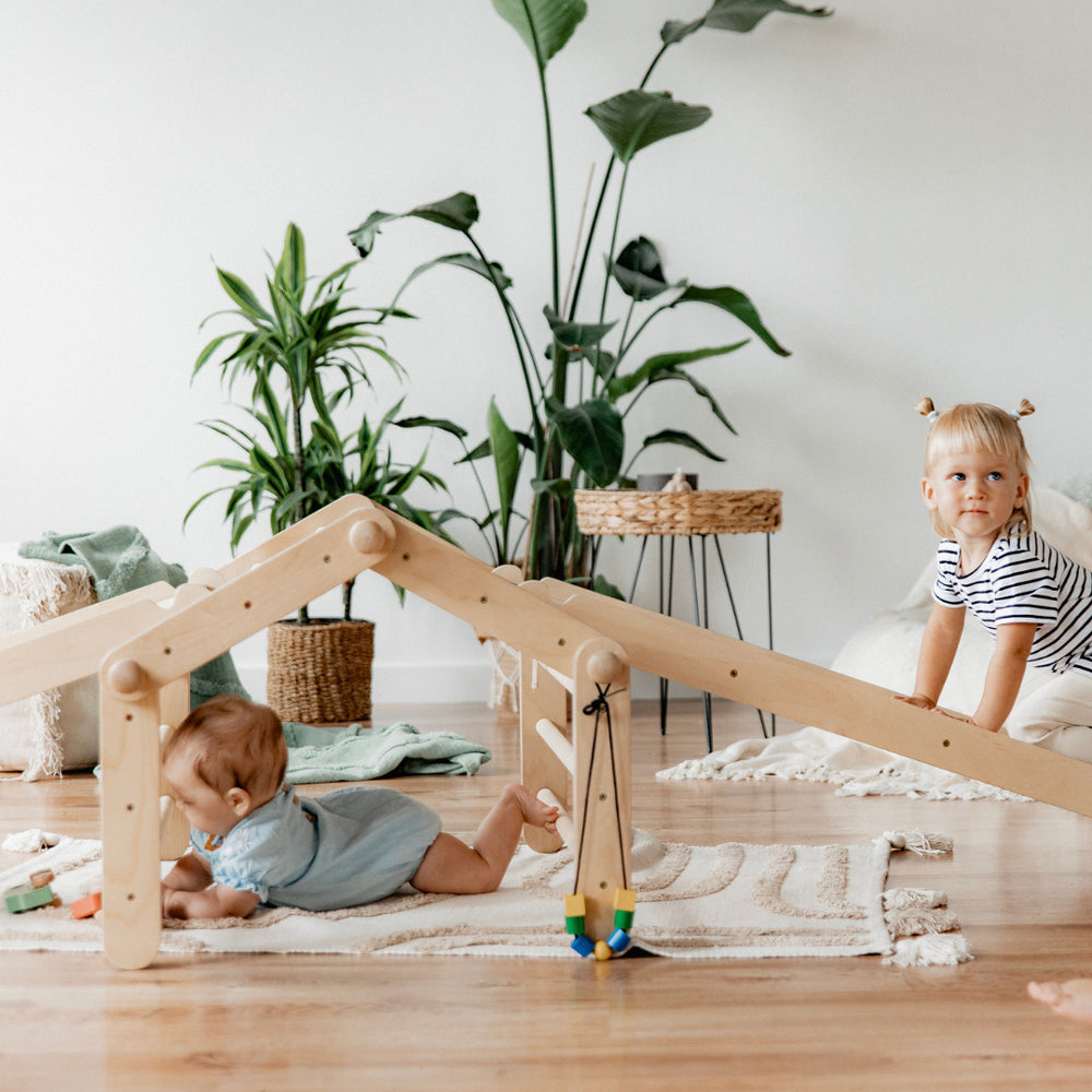 Kinder spielen mit dem natürlichen 4-teiligen Pikler Kletterdreieck mit Rampe im hellen, gemütlichen Spielzimmer für mehr Bewegung und Entdeckung.