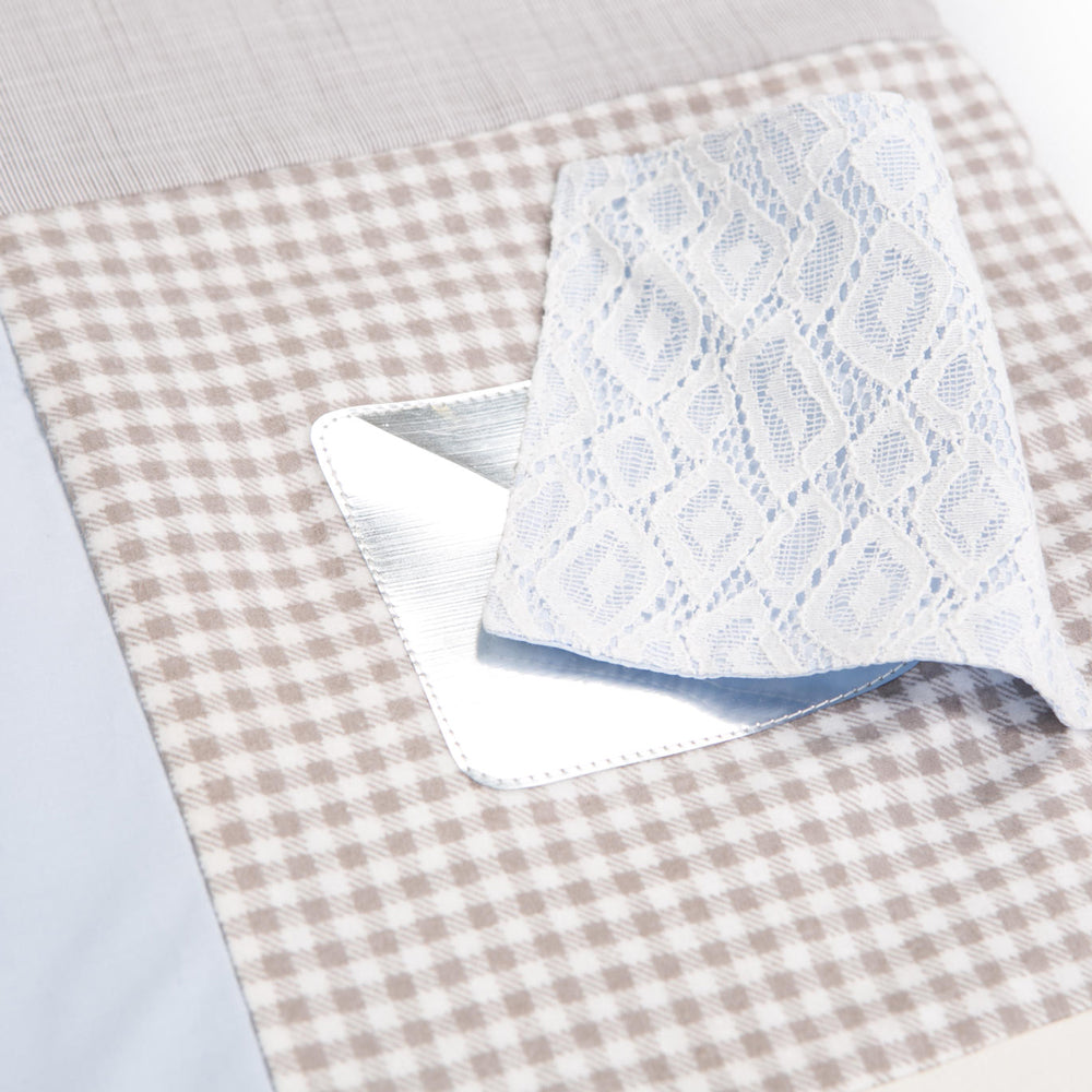 Detailaufnahme einer Baby-Spieldecke mit Patchwork-Design, weicher Baumwolle und abnehmbarem Spielbogen in sanften Blautönen.