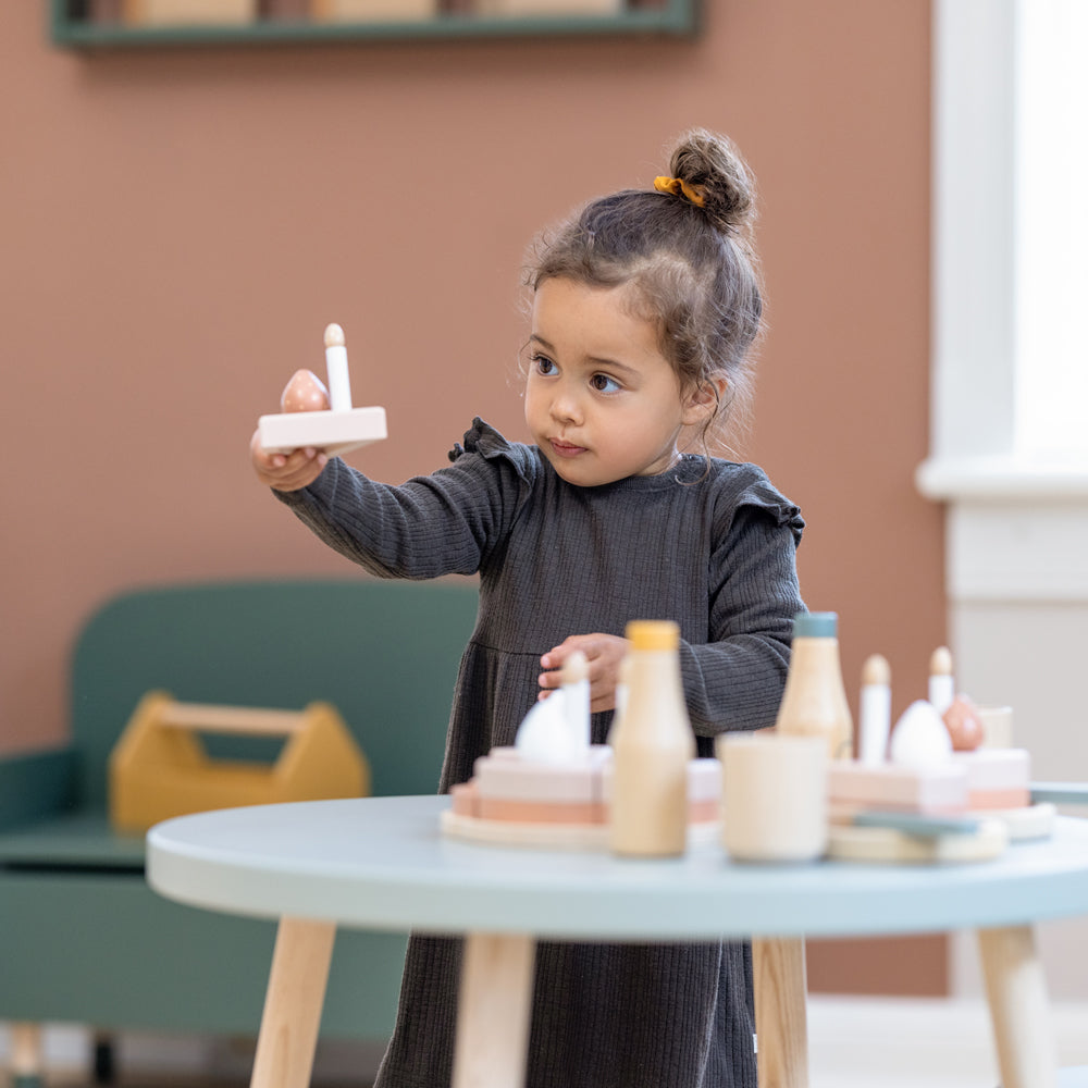 Kind spielt mit dem Geburtstagskuchen-Spielset aus Holz für Kinderküchen, 25 Teile, fördert Kreativität und soziale Fähigkeiten beim Feiern.