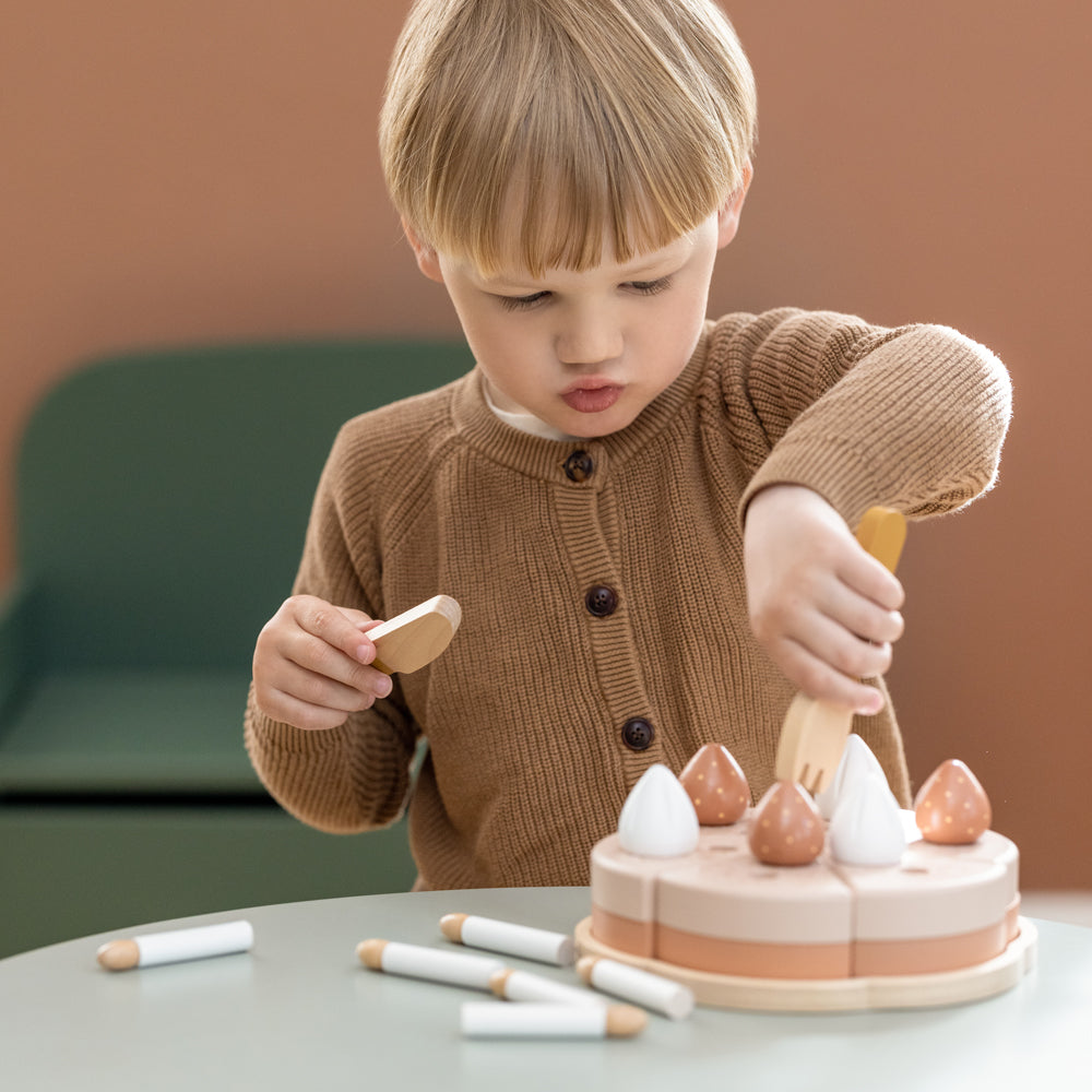 Kleines Kind spielt mit dem 25-teiligen Geburtstagskuchen-Spielset aus Holz für Kinderküchen und verteilt Kuchenstücke.