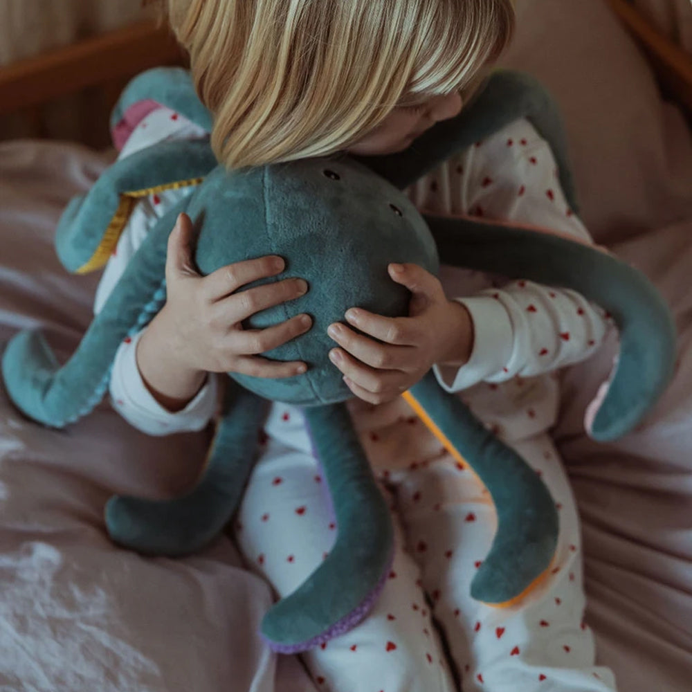 Kind umarmt ein weiches Gewichts-Kuscheltier Plüsch-Oktopus aus der Meer Themenwelt, ideal als Geschenk und für festliche Favoriten.