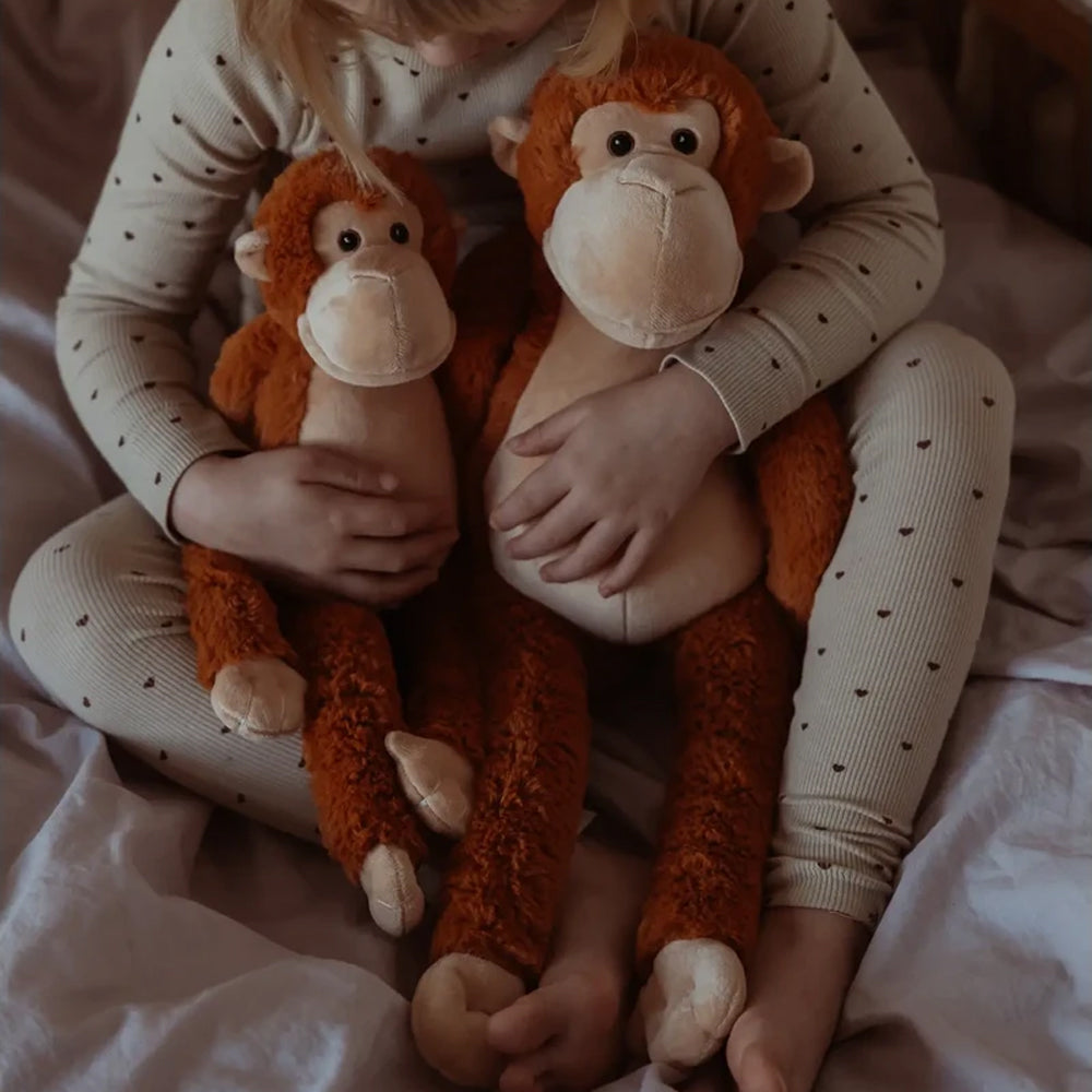 Kind hält zwei weiche Gewichts-Kuscheltiere Plüsch-Affen im Bett aus der Spielzeug & Spiele Tierwelt Themenwelt Sammlung.