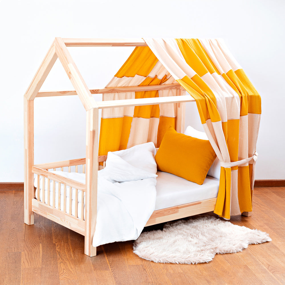 Kinderbett mit kariertem Musselin-Betthimmel in Gelb-Creme, gemütlich und stilvoll für eine warme Wohlfühlatmosphäre im Kinderzimmer.