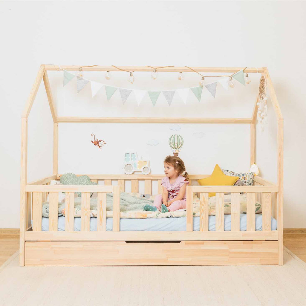 Hausbett Roko mit mittigem Einstieg & Ausziehbett aus FSC-zertifiziertem Kiefernholz, mit Rausfallschutz und praktischem Zusatzbett für Kinderzimmer.