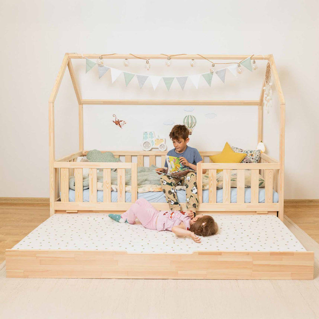 Hausbett Roko mit mittigem Einstieg & Ausziehbett aus FSC-zertifiziertem Kiefernholz, sicher und praktisch für Kinder zum Spielen und Schlafen.