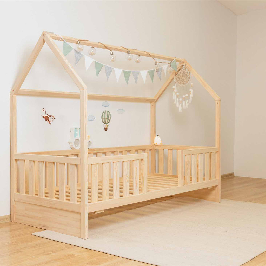 Hausbett Roko mit mittigem Einstieg & Ausziehbett aus FSC-zertifiziertem Kiefernholz, sicher und individuell für Kinderzimmer gestaltet.