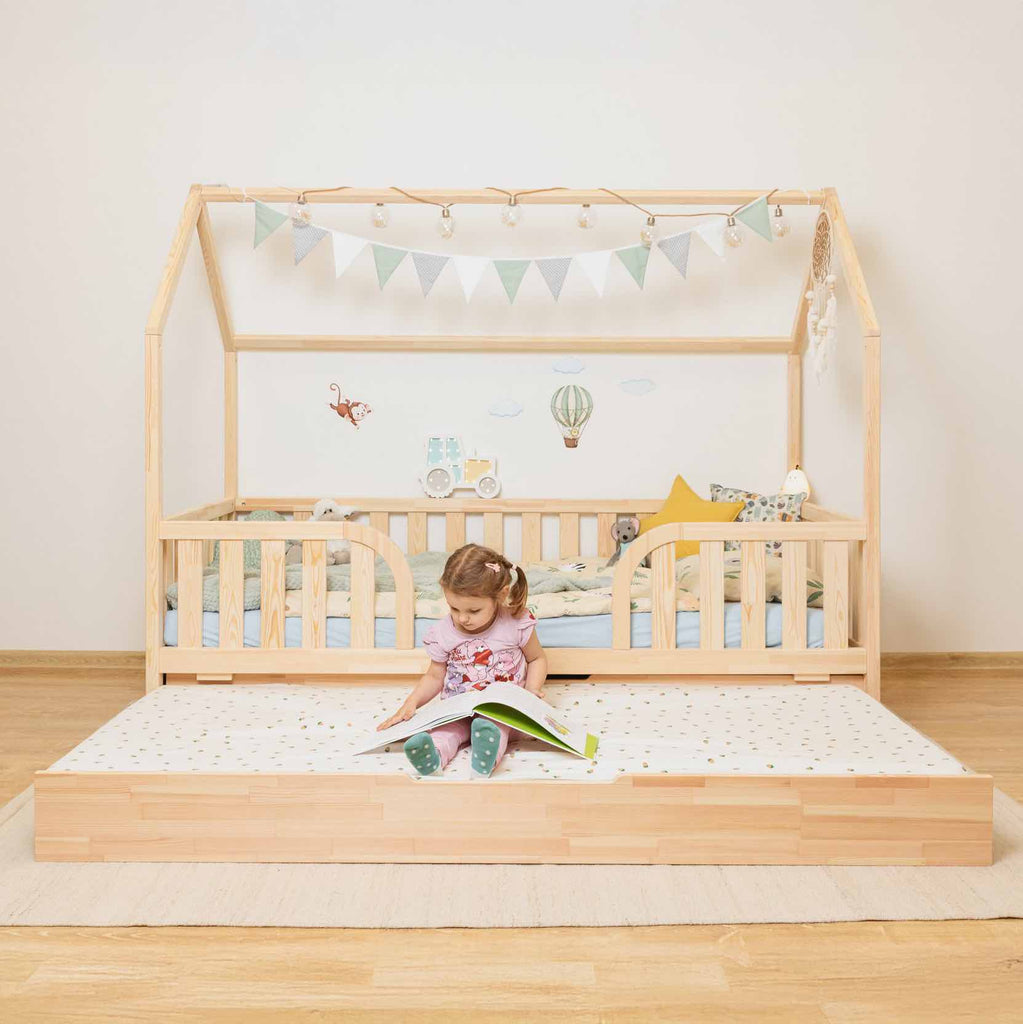 Hausbett Roko mit mittigem Einstieg & Ausziehbett aus FSC-zertifiziertem Kiefernholz, natur, mit Rausfallschutz und zusätzlichem Ausziehbettkasten.