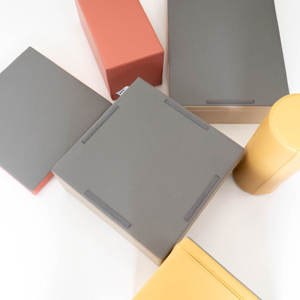 Softblock 7-teiliges Bausteinset in herbstlichen Pastellfarben, fördert Motorik und Kreativität bei Kindern im Gelben Kinderzimmer.