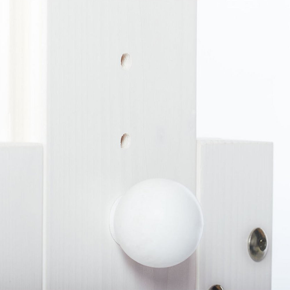 Nahaufnahme eines weißen, höhenverstellbaren Kinderschreibtischs aus Kiefernholz mit verstellbaren Löchern für Tische im Kinderzimmer.