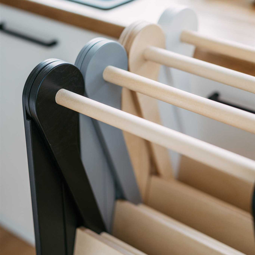 Drei klappbare und höhenverstellbare Lerntürme aus Holz in Schwarz, Grau und Natur für Spielmöbel und Montessori Spiel & Bewegung Kinder.