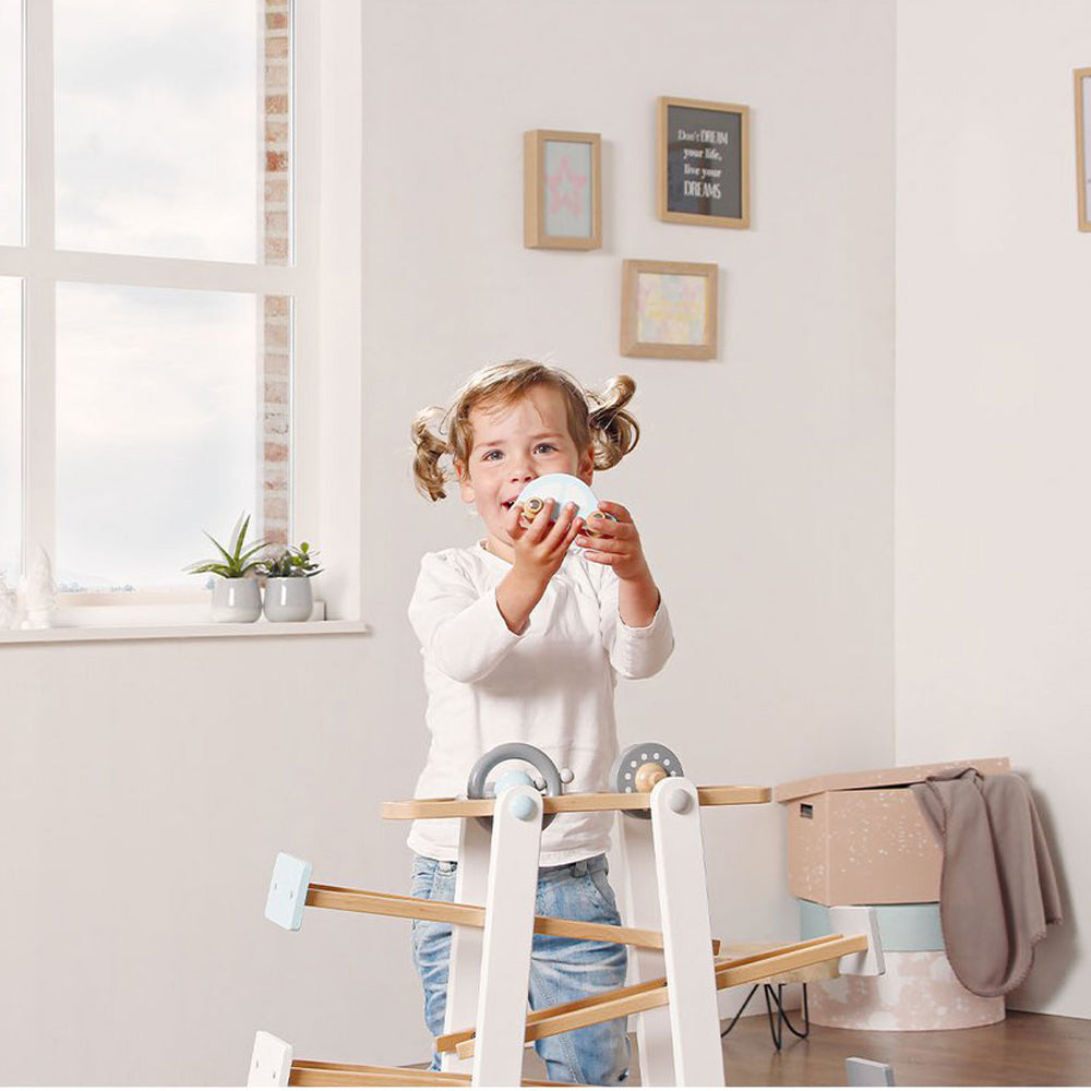 Kleines Mädchen spielt mit Kugelbahn Motorikspielzeug aus Holz, ideal für Motorik- & Holzspielzeug in Spielzeug & Spiele Sammlung.