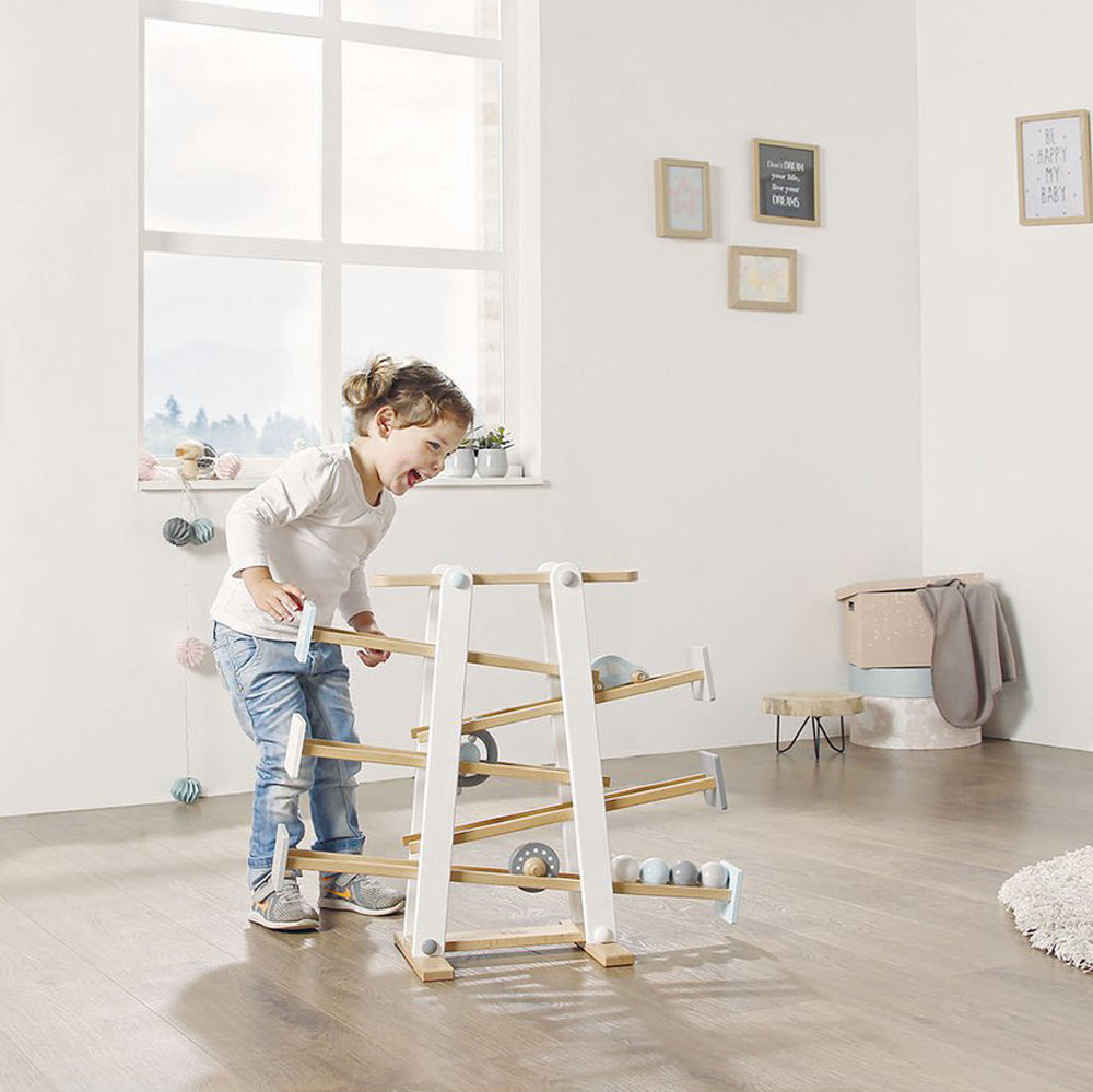 Kind spielt begeistert mit kleinem Kugelbahn Motorikspielzeug aus Holz, ideal für Spiel & Bewegung Kinder sowie Motorik- & Holzspielzeug Sammlungen.