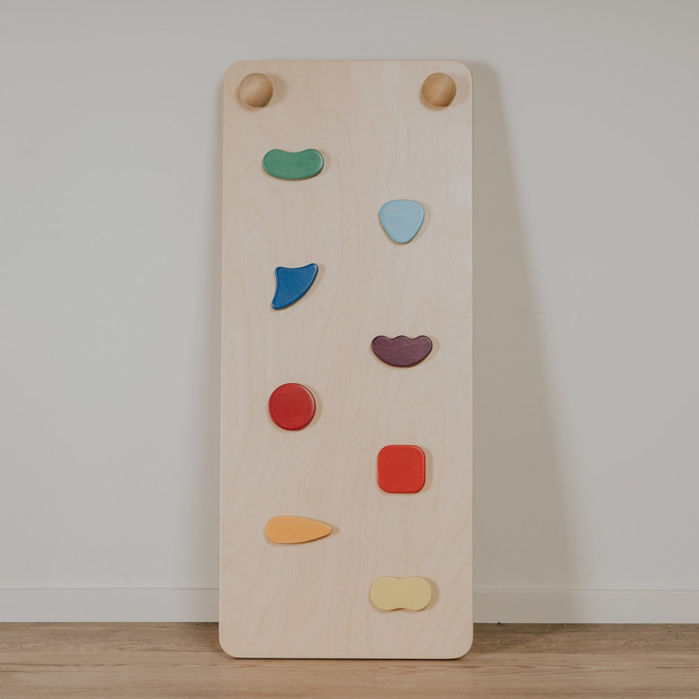 Natürliches Kletterbrett aus Birkenholz mit bunten Griffen für motorisches Spielen und Förderung von Gleichgewicht und Koordination.