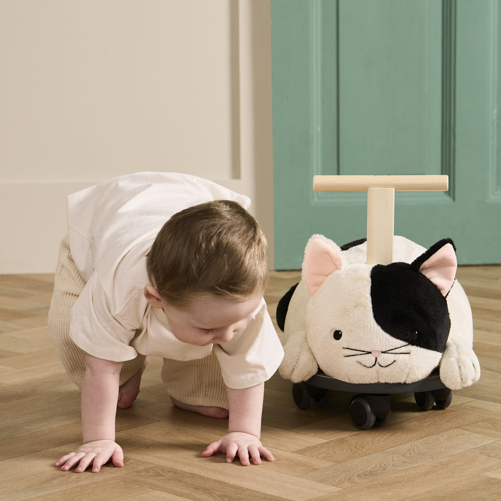 Kleines Kind krabbelt neben dem weichen Rutschfahrzeug Katze Aiden aus Spielzeug & Spiele, perfekt für Fahr- und Bewegungsspielzeug.