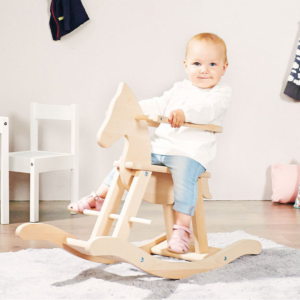 Kleines Kind sitzt fröhlich auf einem Schaukelpferd aus Holz mit Sicherheitsbügel, ideal für Spielzeug & Spiele, Fahr- und Wippspielzeug.