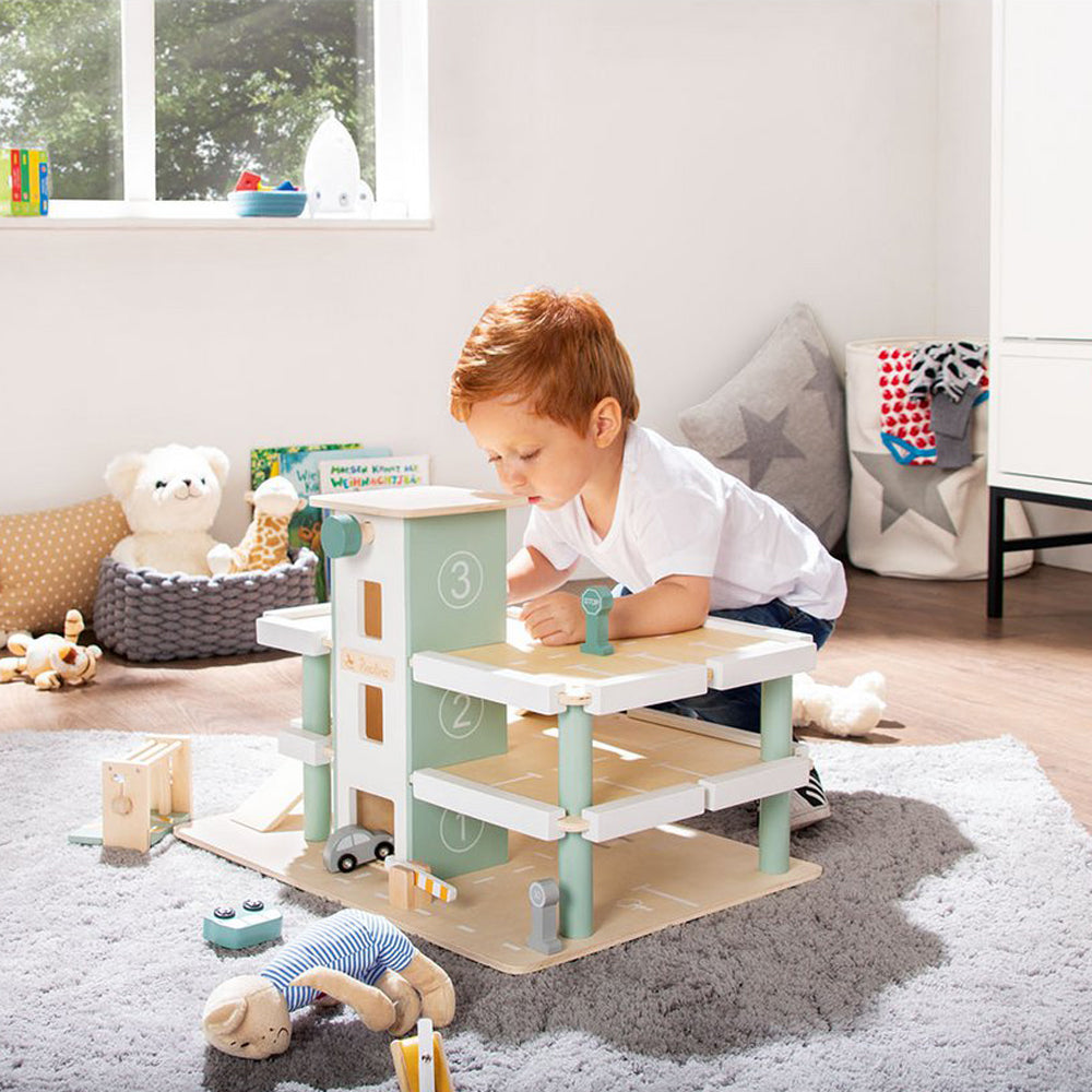 Kind spielt mit Spielparkhaus aus Holz mit Fahrzeugen im Kinderzimmer aus der Themenwelt Fahrzeuge & Transport, Motorikspielzeug Neu in Spiel & Bewegung