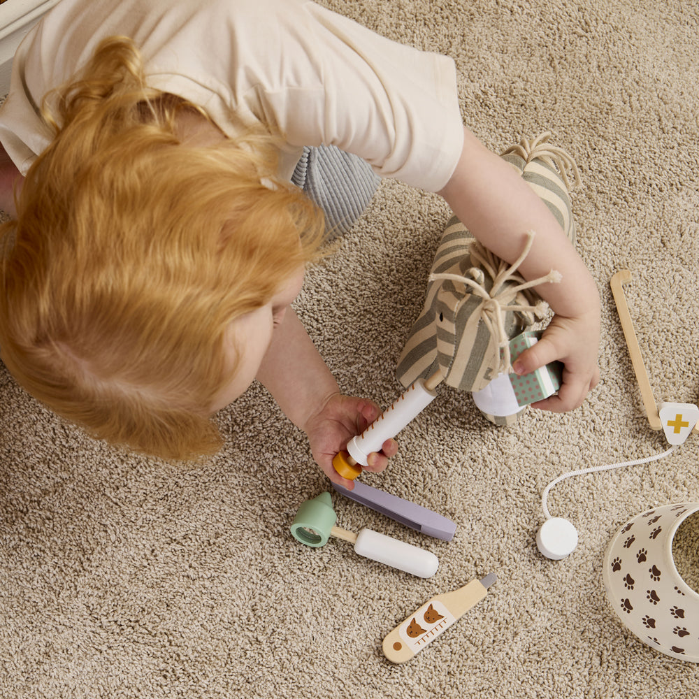 Kind spielt mit dem Tierarztkoffer-Spielset aus Holz, Untersuchungsspielzeug für Kinder aus der Kategorie Motorik- & Holzspielzeug.