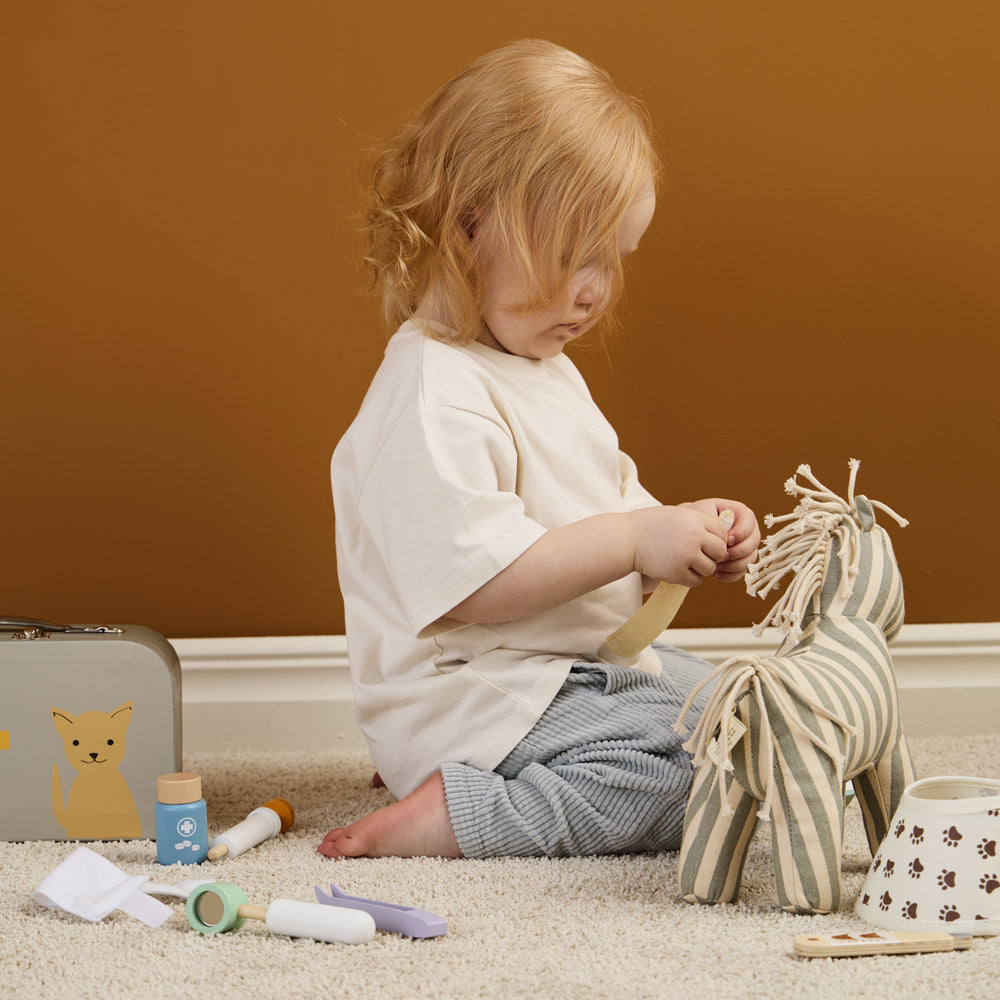 Kleines Kind spielt mit Tierarztkoffer-Spielset aus Holz, motorisches Spielzeug aus der Kollektion Spielzeug & Spiele für kreative Kinder.
