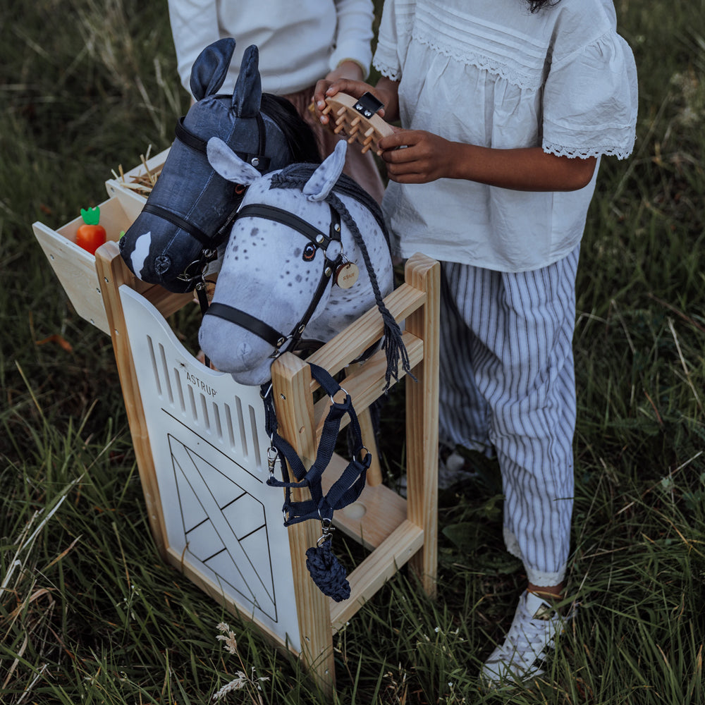 Kinder spielen mit grauem und schwarzem Hobby Horsing Steckenpferd aus der Spielzeug & Spiele Tierwelt Themenwelt Sammlung