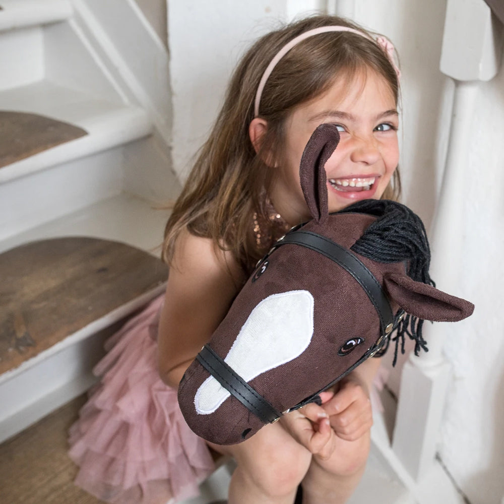 Mädchen freut sich mit Steckenpferd offenes Maul in braun, Spielzeug & Spiele aus der Tierwelt Themenwelt für Kinder Spaß und Bewegung.