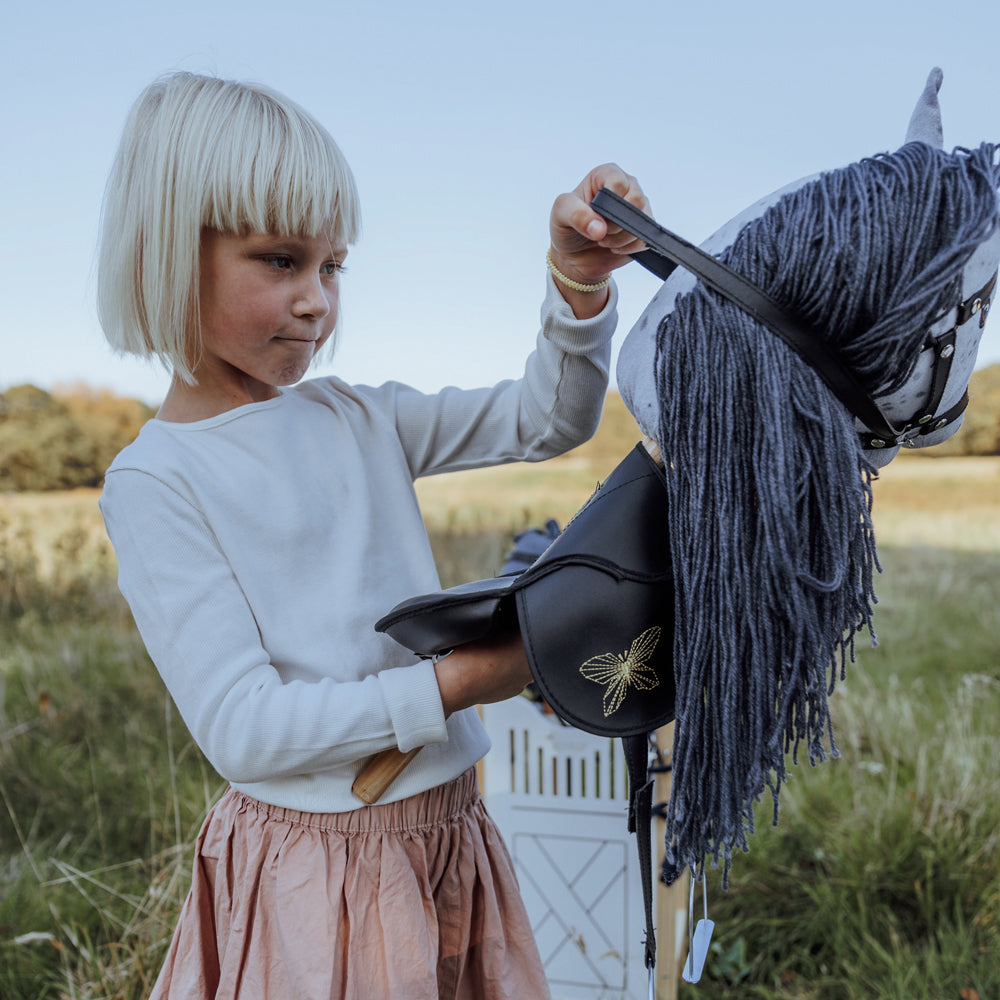 Kind spielt mit grauem Steckenpferd mit offenem Mund im Freien aus der Spielzeug & Spiele Sammlung Hobby Horsing Tierwelt