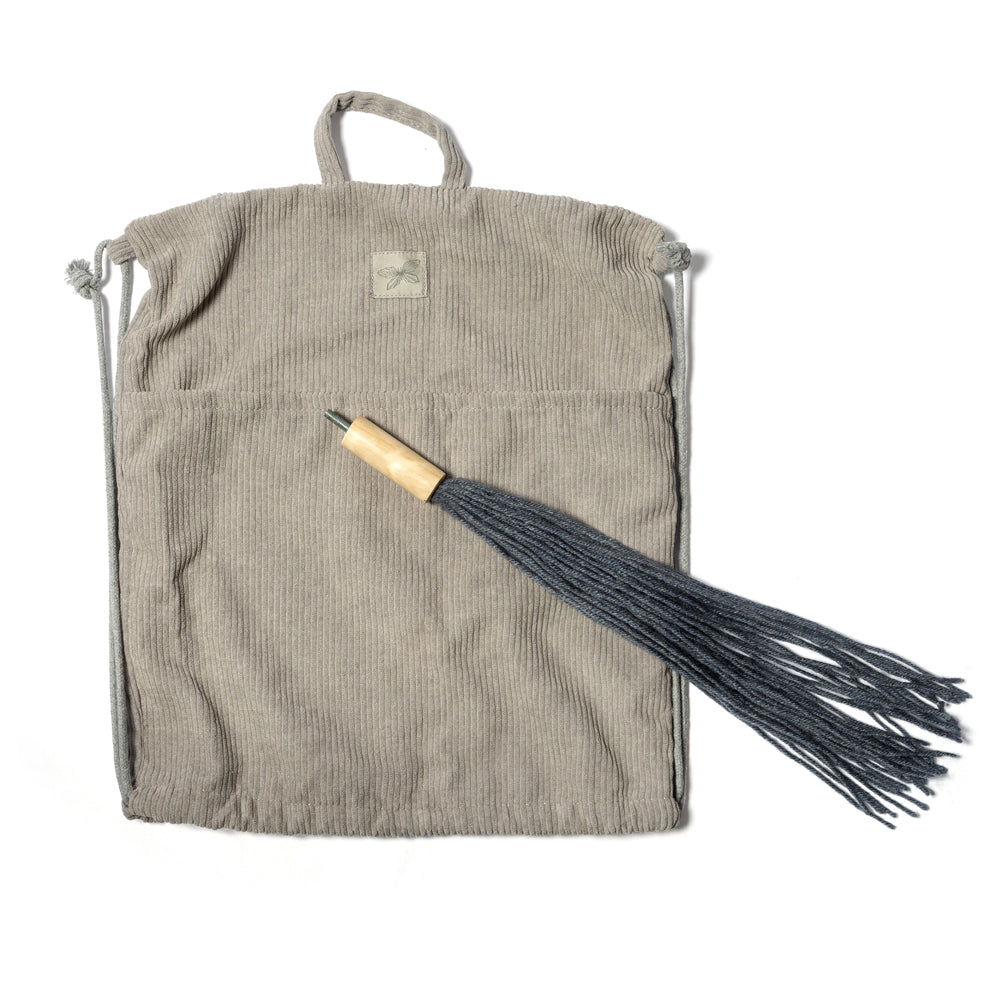 Grauer Steckenpferdkopf mit offenem Maul und schwarzen Fransen, dazu passender grauer Stoffbeutel aus der Spielzeug & Spiele Sammlung.