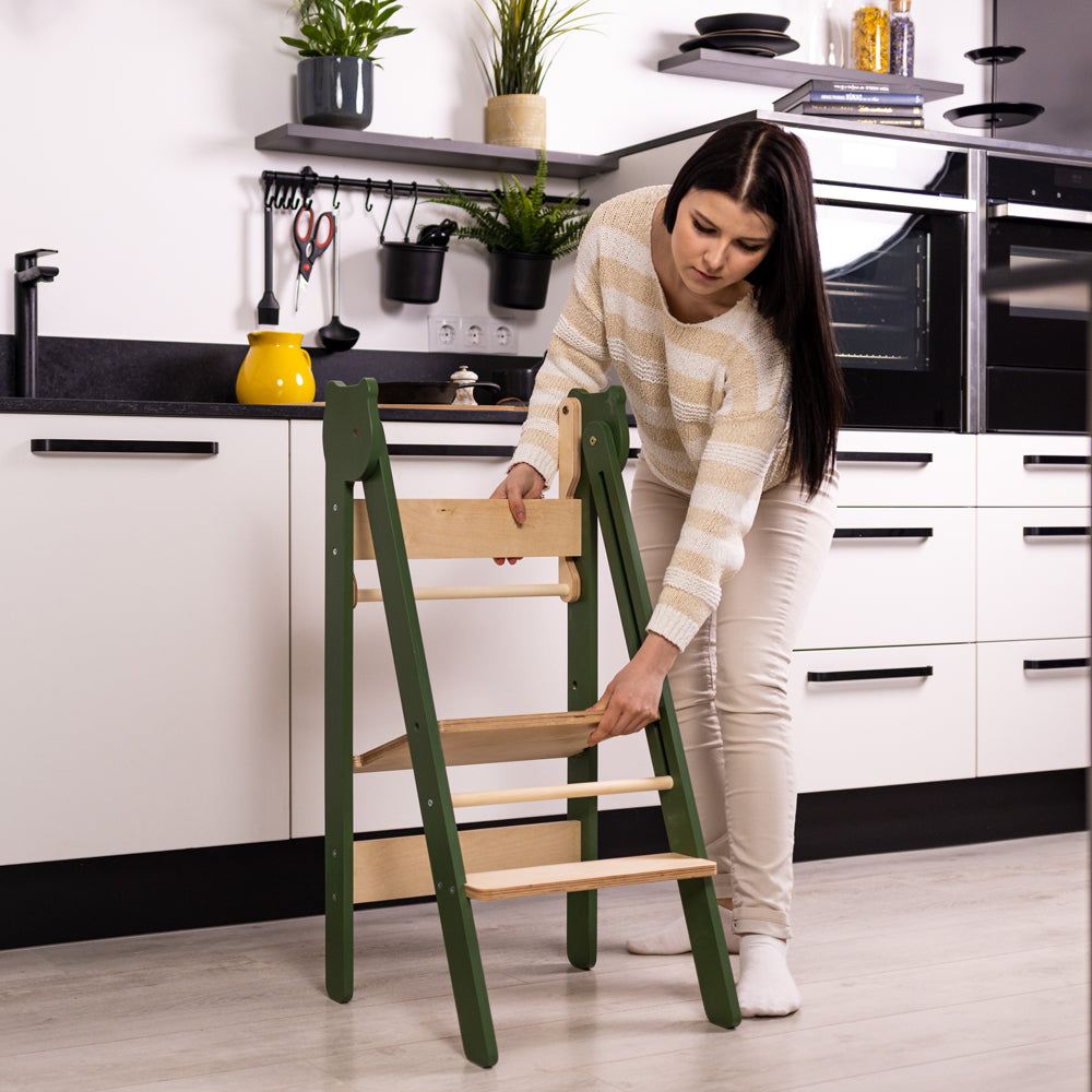 Frau stellt Tritthocker Lernstuhl klappbar mit 2 höhenverstellbaren Stufen in modernem weißen Küchendesign auf Neu, Stühle & Hocker
