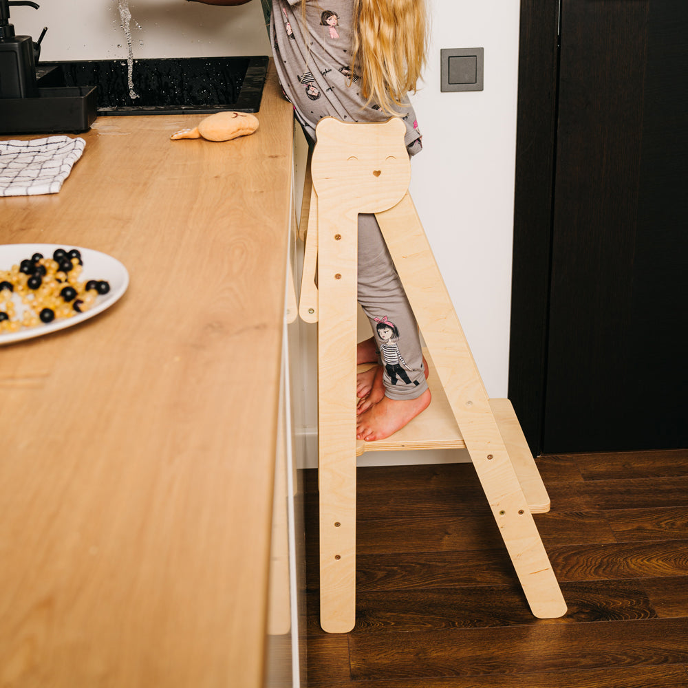 Kind auf Tritthocker Lernstuhl klappbar mit 2 höhenverstellbaren Stufen in gelbem Kinderzimmer, Montessori inspiriert, praktische Stühle & Hocker.