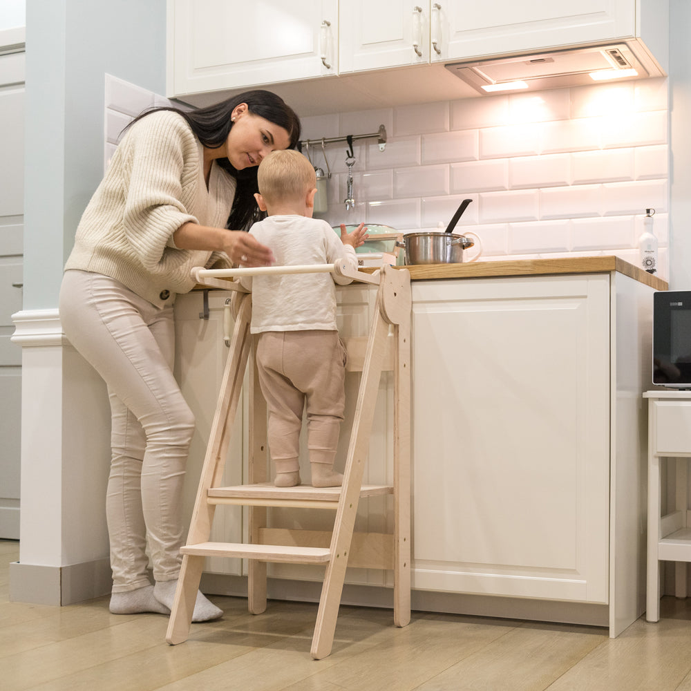 Mutter und Kind nutzen den höhenverstellbaren Tritthocker Lernstuhl in der Küche aus der Pikler & Montessori Kollektion Neu Stühle & Hocker Gelbes Kinderzimmer