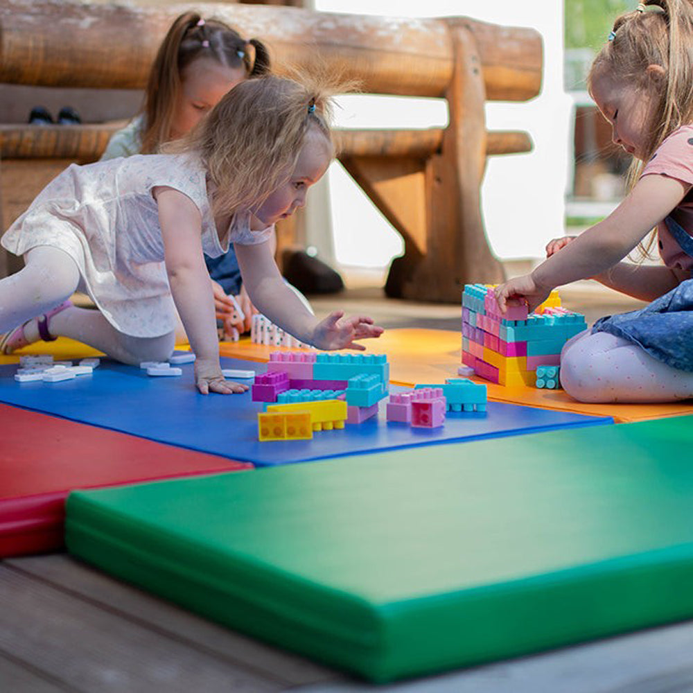 Kinder spielen auf bunten, weichen Turn- und Spielmatten, ideal für Spiel & Bewegung Kinder im gelben Kinderzimmer und Spielzeug & Spiele.