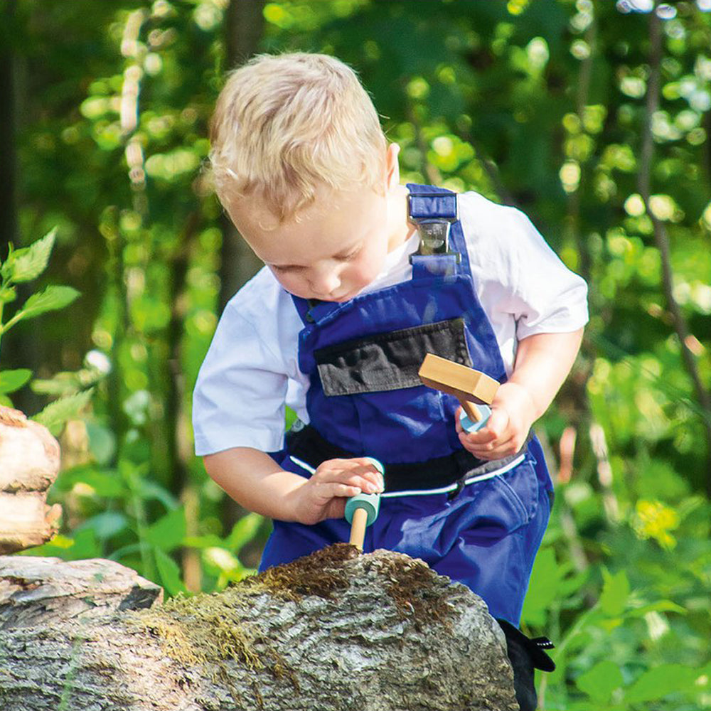 Kleiner Junge spielt draußen mit Werkbank-Spielset aus Holz, ideal für Motorik- & Holzspielzeug, Spiel & Bewegung Kinder, Geschenke, Neu.